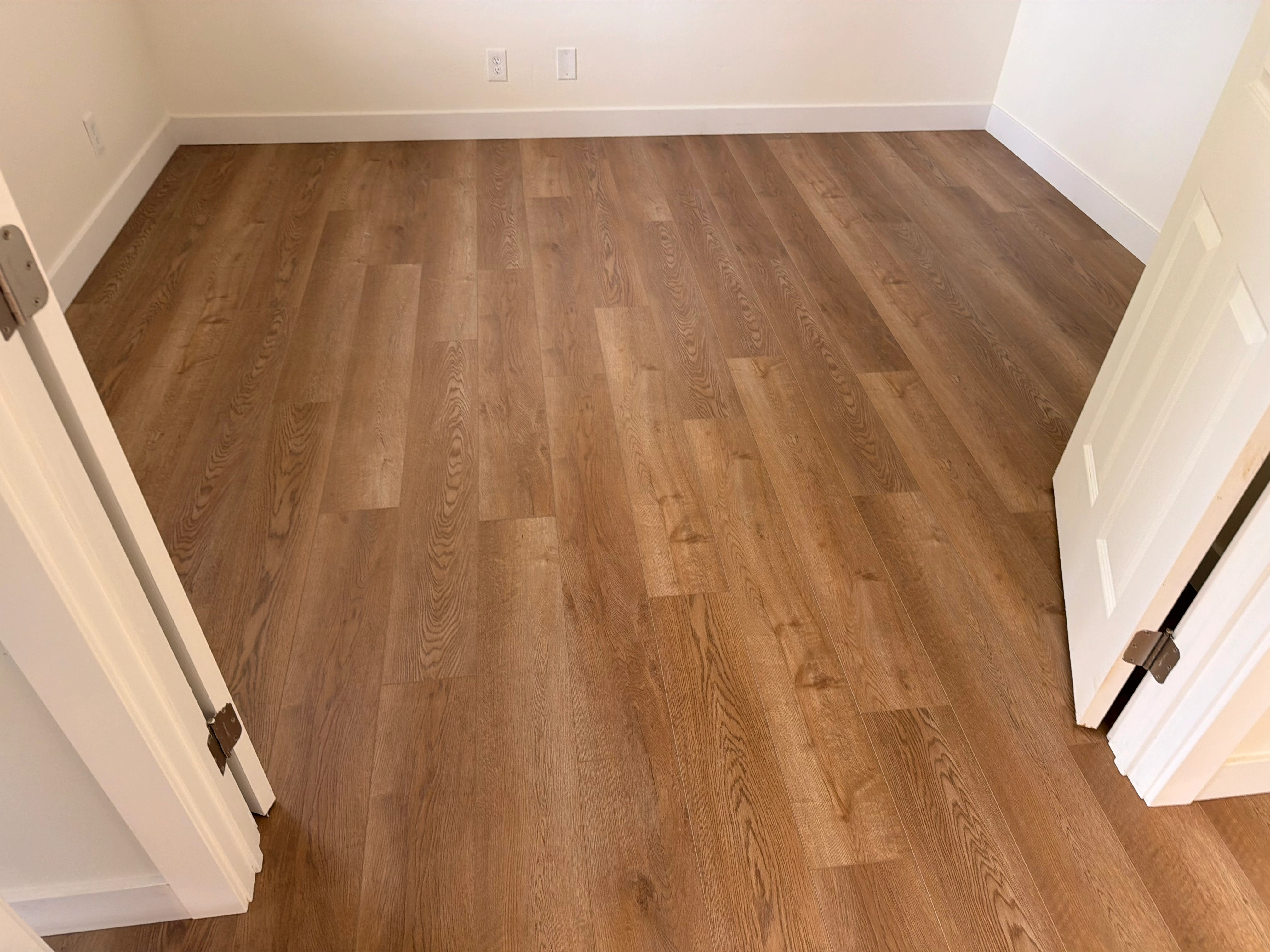 Side by side comparison of hardwood and luxury vinyl plank flooring samples